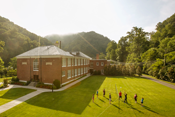 A group of people walking on a grassy hill