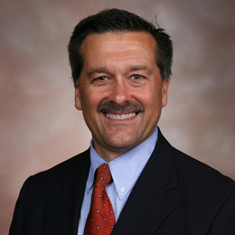 A smiling man in a suit and tie