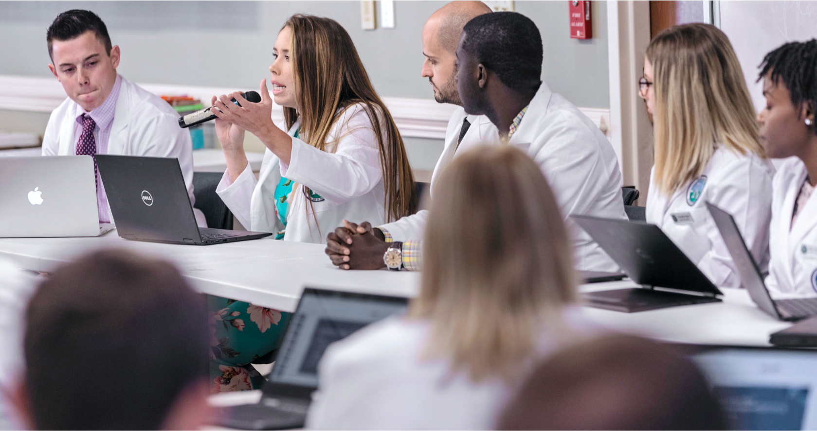 students in white coats in class