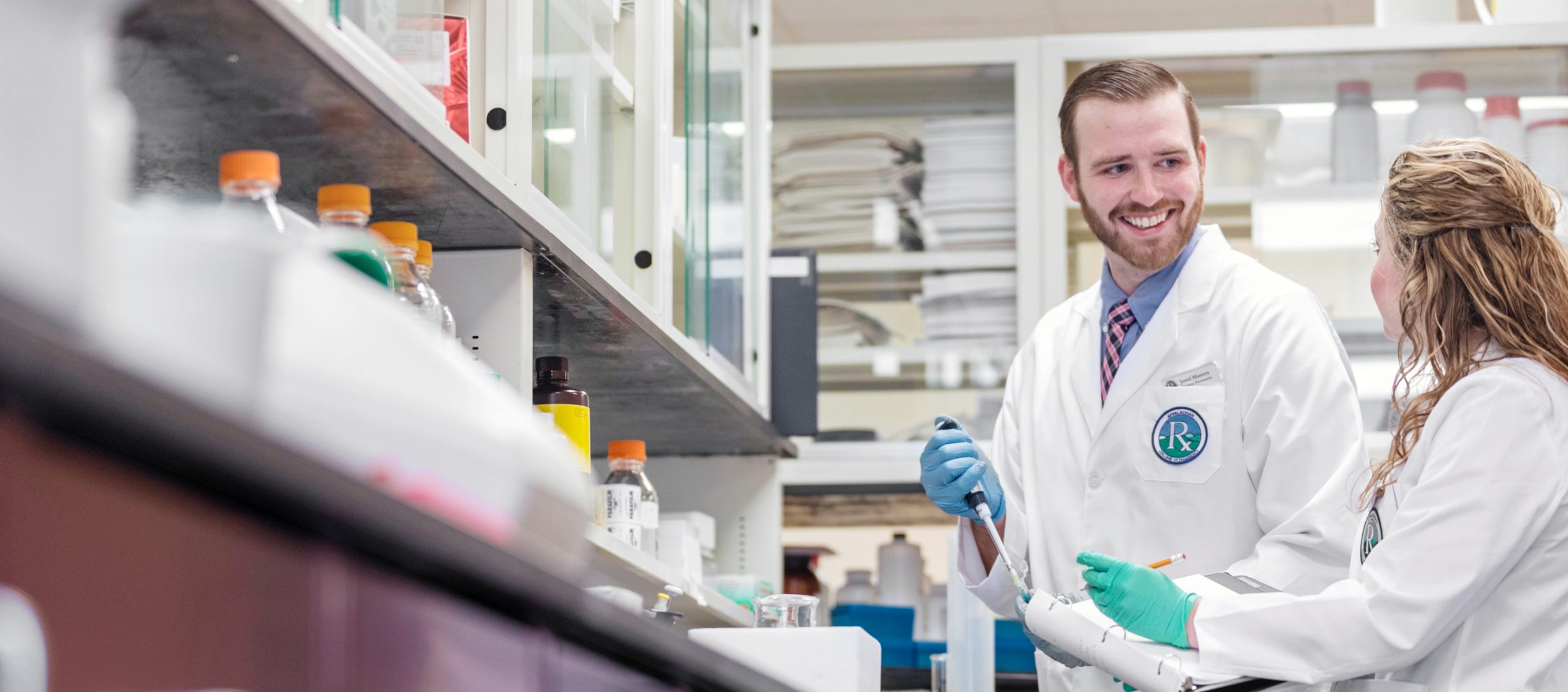 two students in lab coats