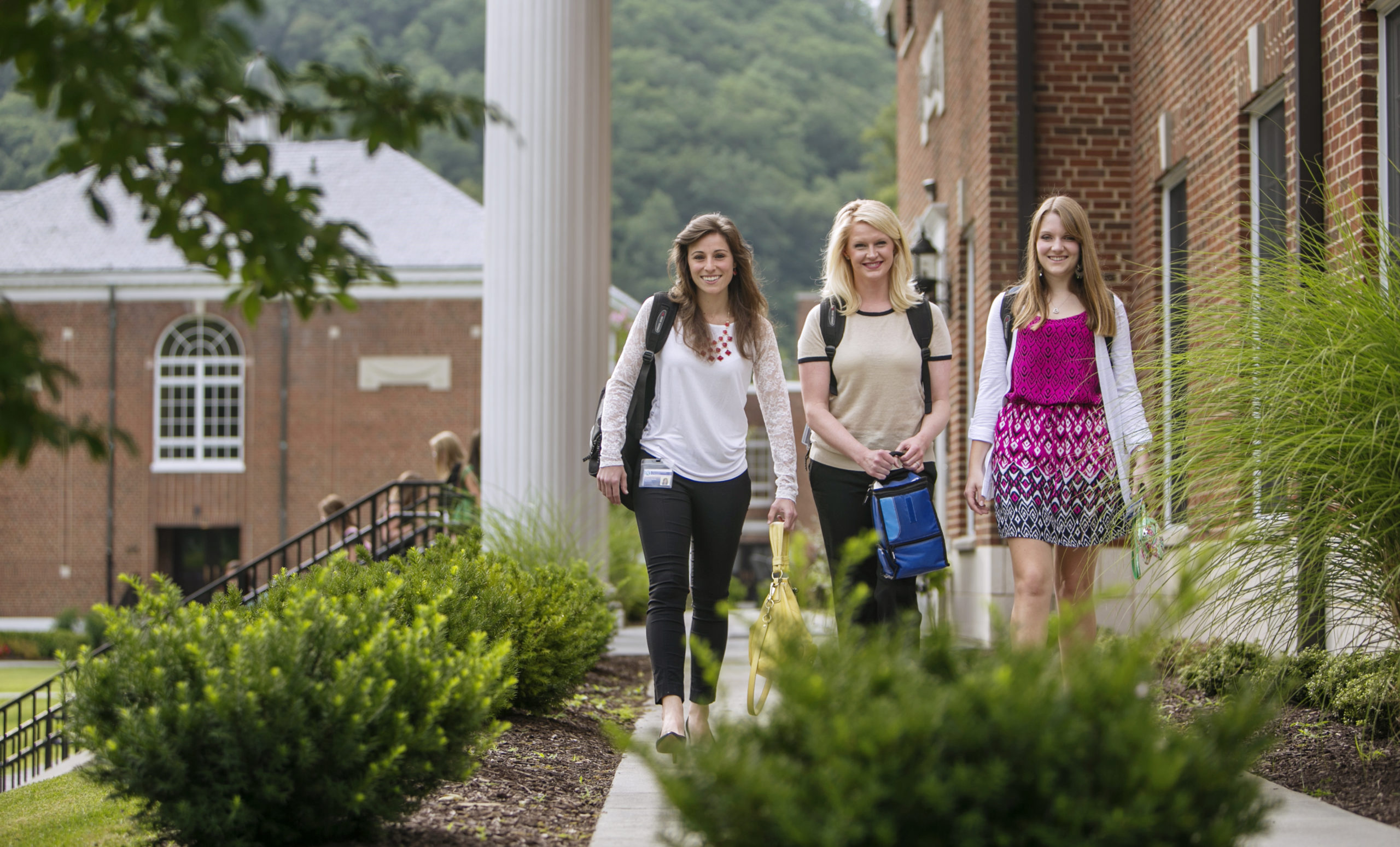 three female students on campus smiling