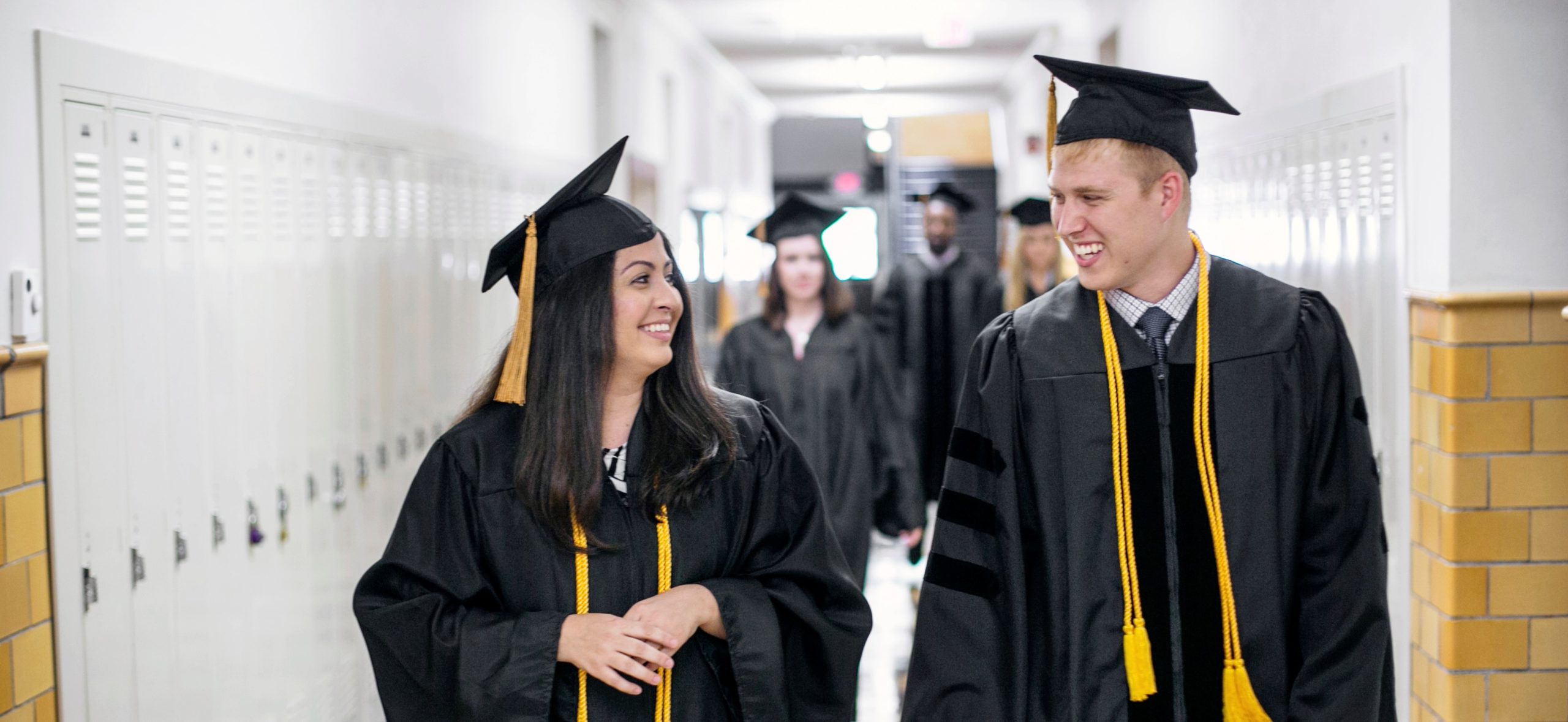 graduation students in cap and gown smiling